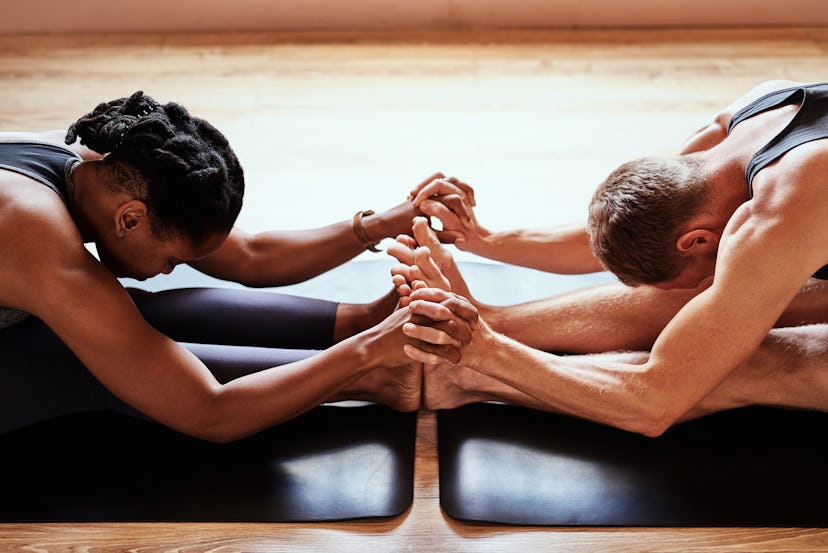 man and woman stretching on mat for partner yoga