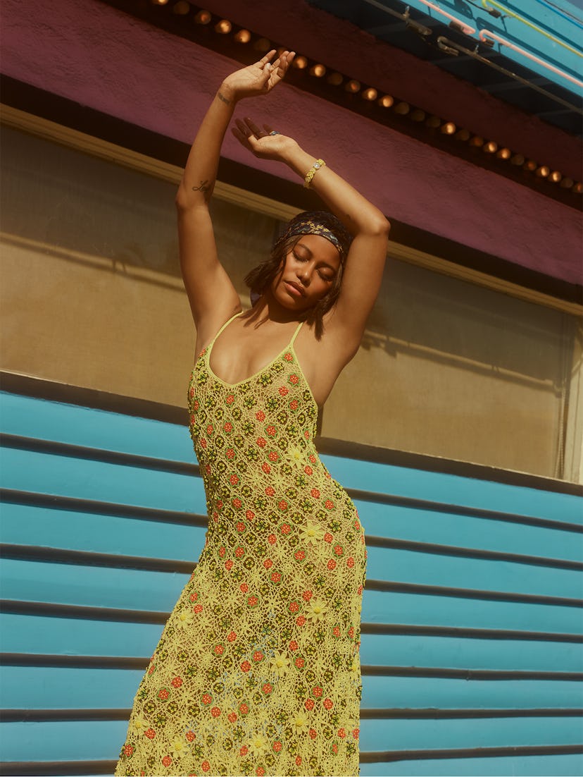 'Zola' star Taylour Paige poses outside with her arms in the air wearing a yellow Bottega Veneta dre...