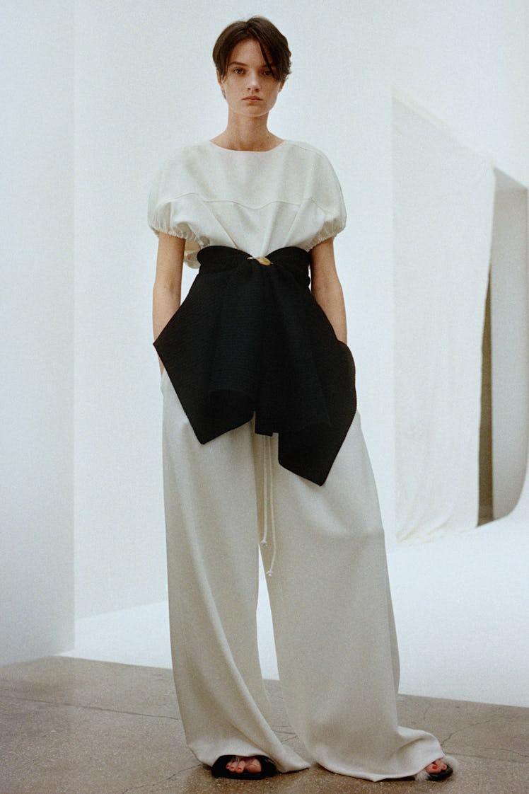 A woman posing in a Proenza Schouler white and black shirt and white baggy pants