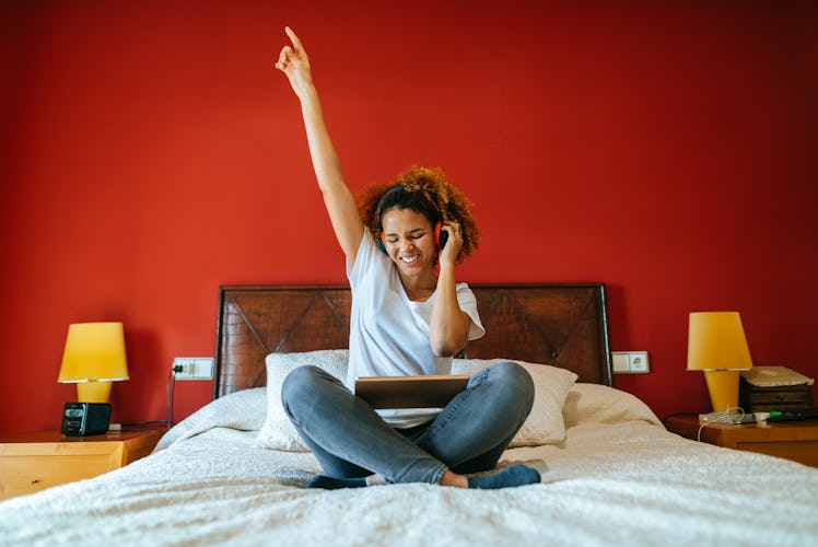 Young woman listening to music on a Sunday morning before posting a pic on Instagram with a fun capt...
