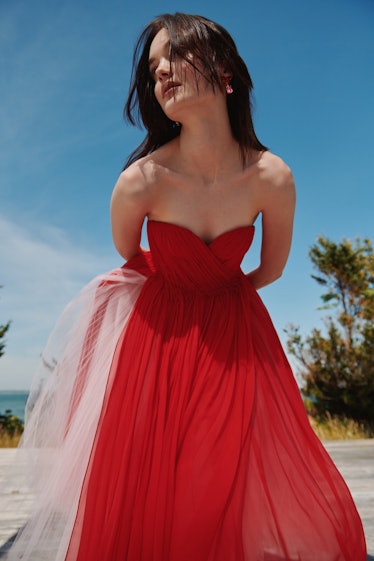 A woman posing in a red Oscar de la Renta gown