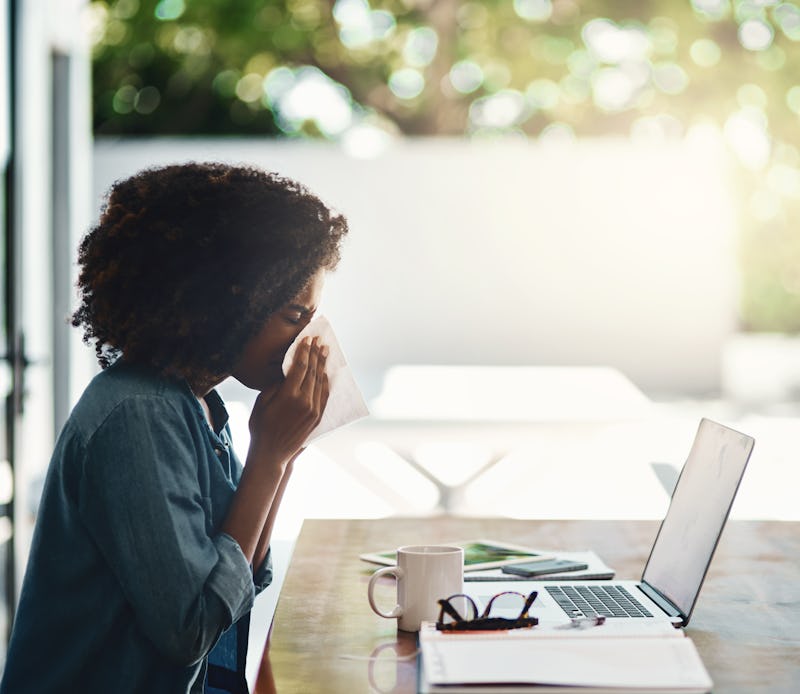 Woman clearly struggling with allergy season while working from home