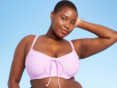 A Black model with short hair wears one of the under-$70 swimsuits from Target's summer 2021 collect...