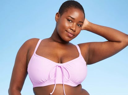 A Black model with short hair wears one of the under-$70 swimsuits from Target's summer 2021 collect...