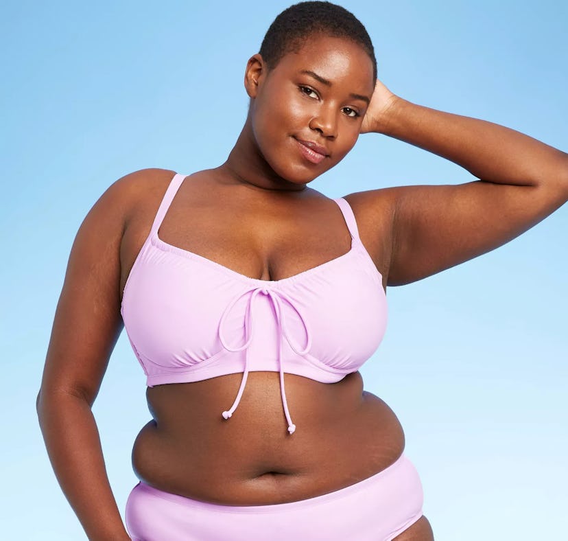 A Black model with short hair wears one of the under-$70 swimsuits from Target's summer 2021 collect...