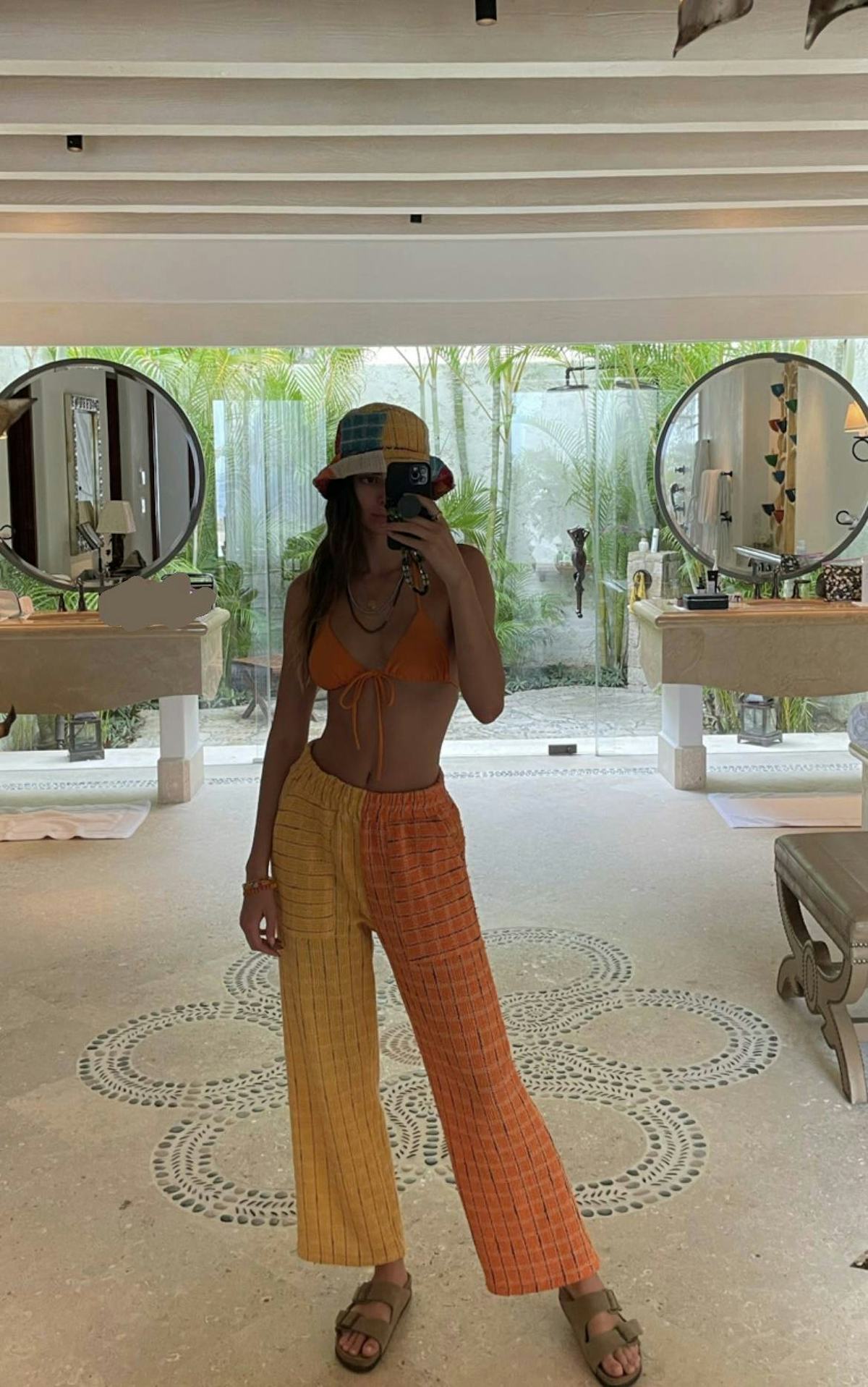 Kendall Jenner in orange and yellow lounge pants.