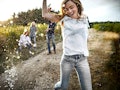Young woman on a dirt road with her family behind her before posting a picture on Instagram with a f...