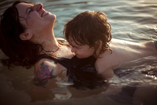 toddler laying on his mom in the sea