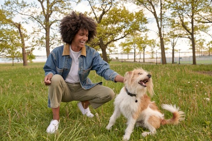 Man in vintage banana republic outfit playing with his dog in the park