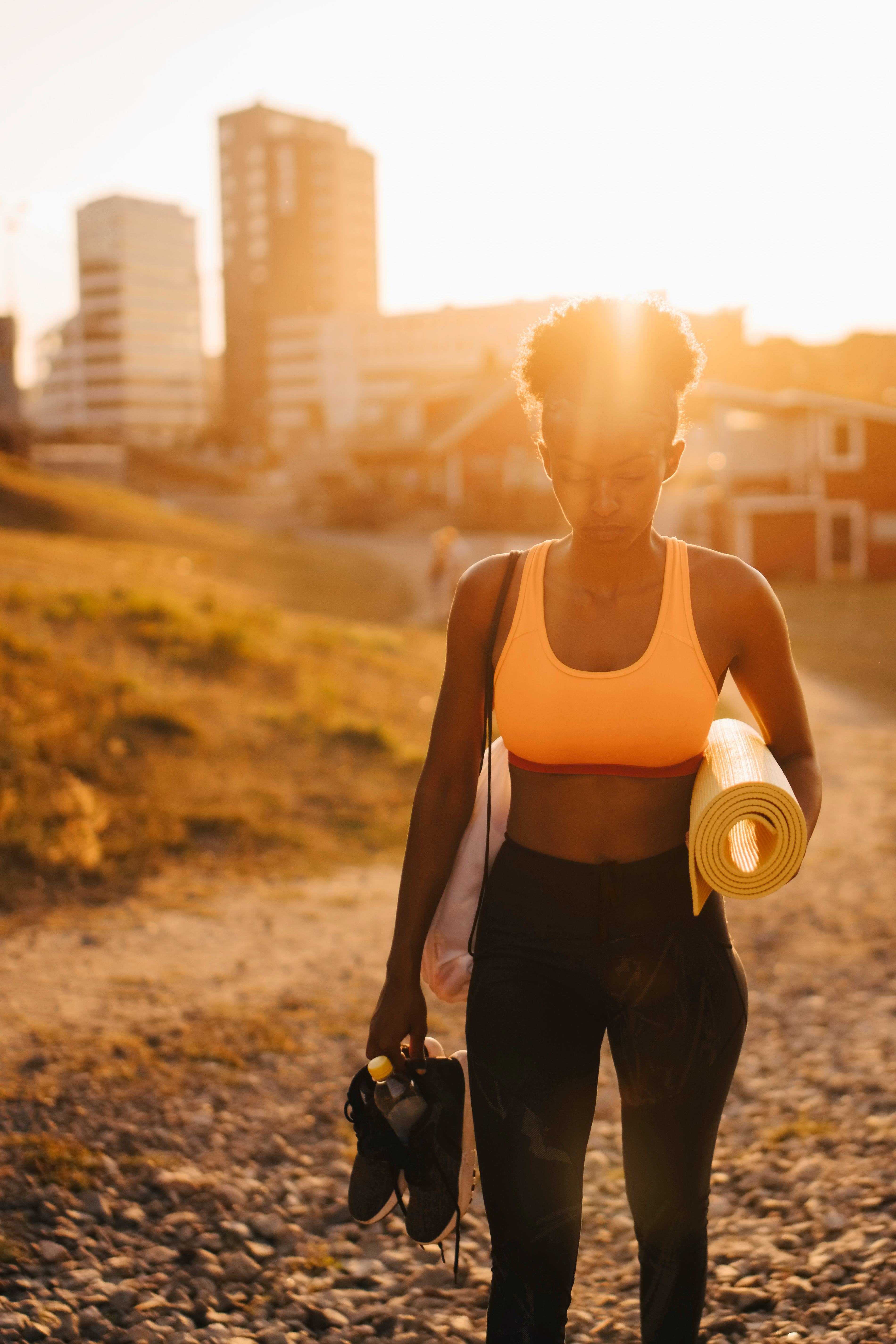 Young woman on her way to do unique summer fitness activities at sunrise.