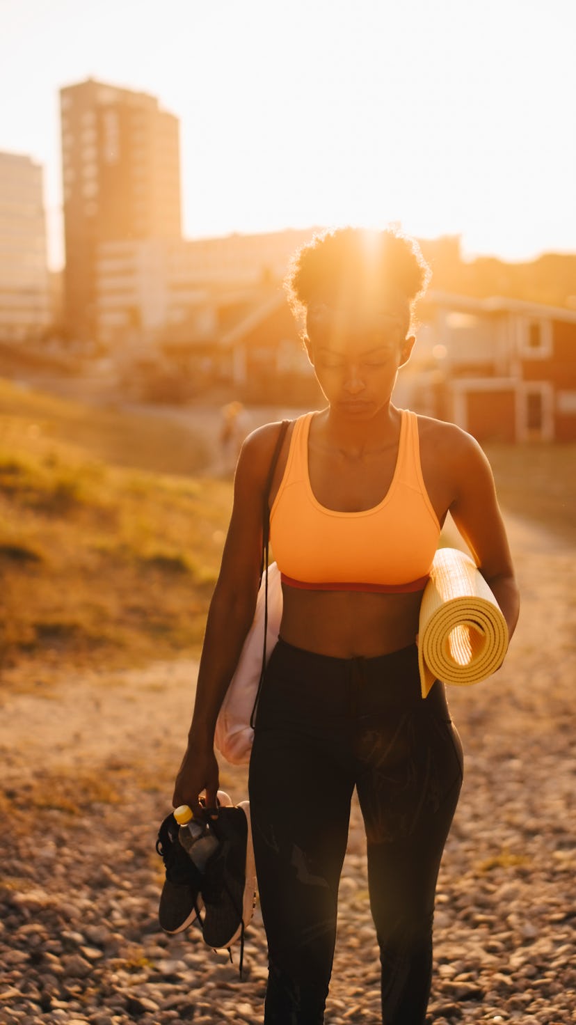 Young woman on her way to do unique summer fitness activities at sunrise.