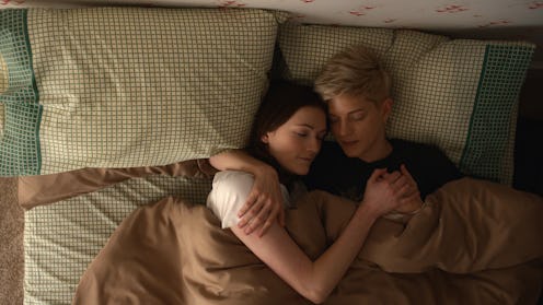 Mae Martin and Charlotte Ritchie in a still from Feel Good, cuddling in bed.