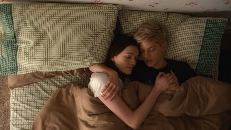 Mae Martin and Charlotte Ritchie in a still from Feel Good, cuddling in bed.