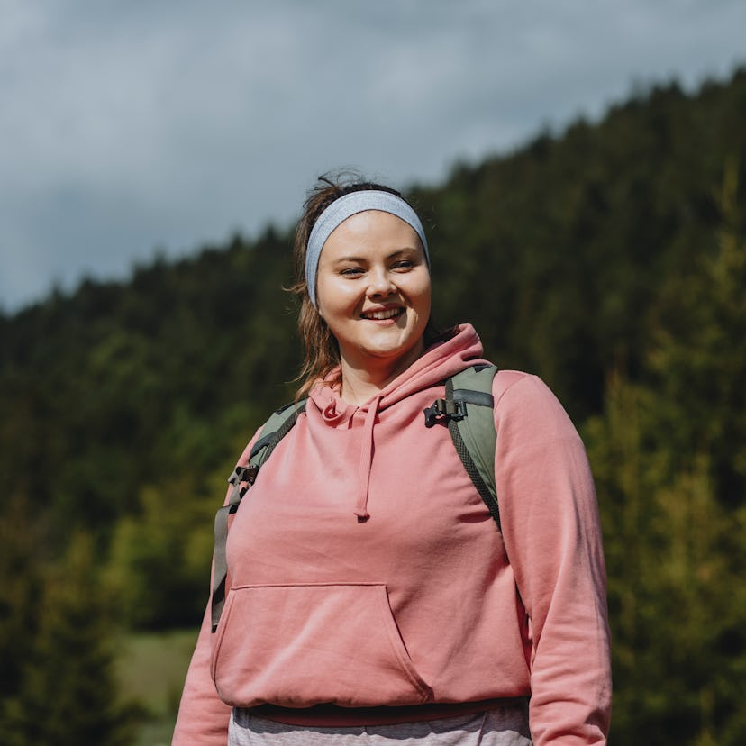 Young woman hiking in Colorado, waiting to post a caption on Instagram.