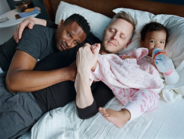 Harrison and Christopher laying in bed with their daugther Genhi