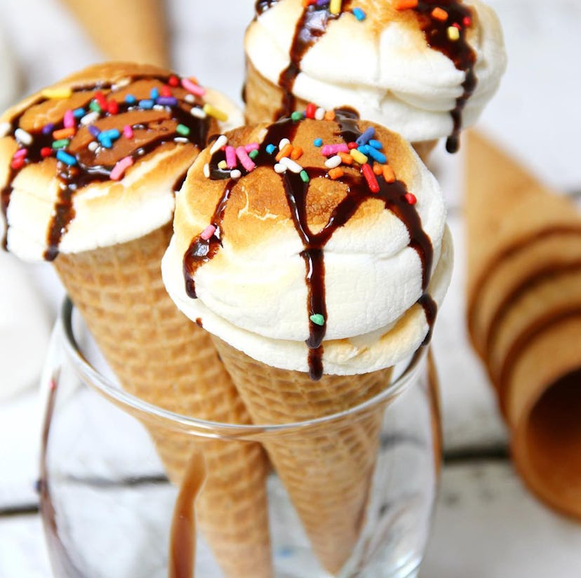 Toasted marshmallows in ice cream cones with chocolate drizzle and sprinkles on top