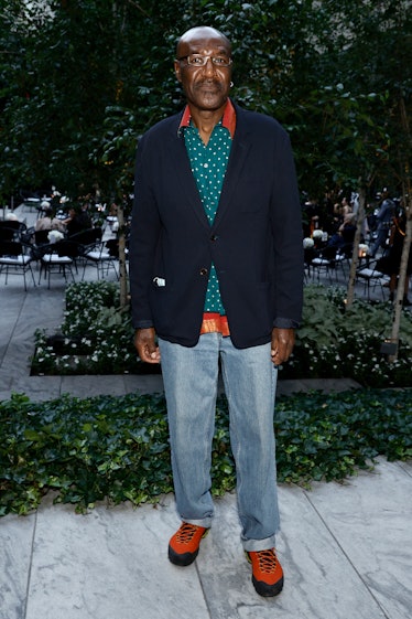 Delroy Lindo in a dark blue blazer and a polka-dotted green button-up with jeans 