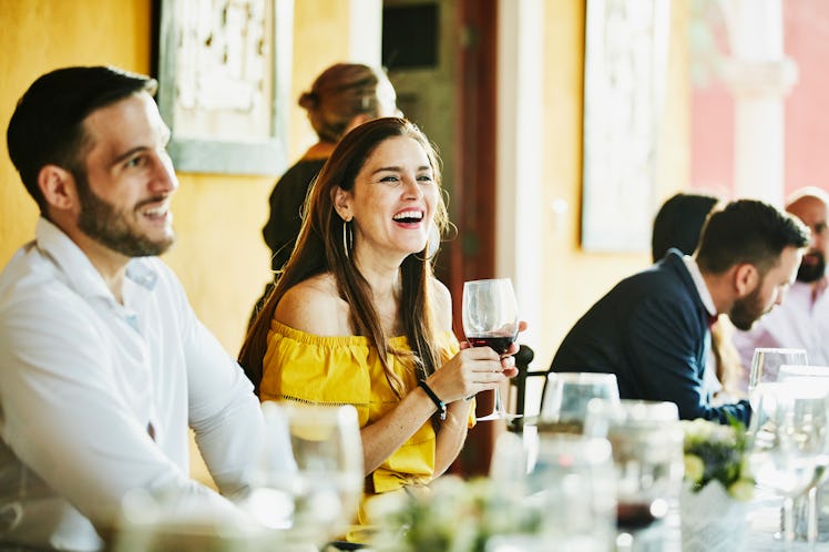 Young woman smiling holding wine at a wedding before posting on social media with Instagram captions...