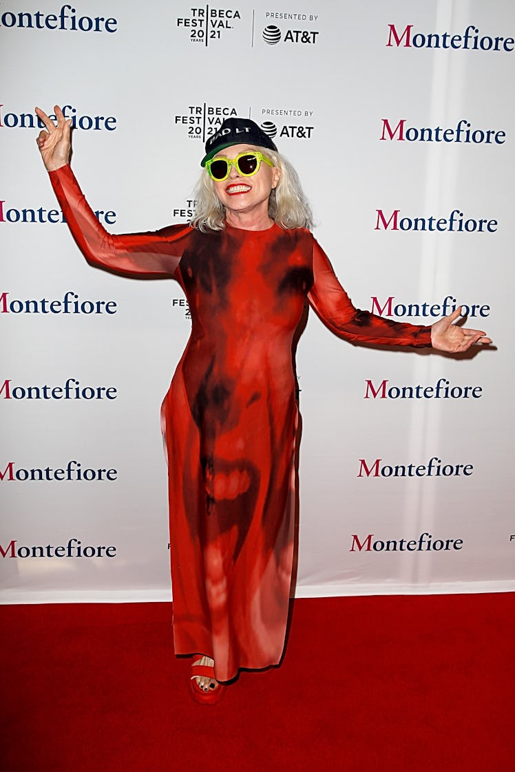 Debbie Harry in a red gown, a black cap and green sunglasses the the Tribeca Film Festival 