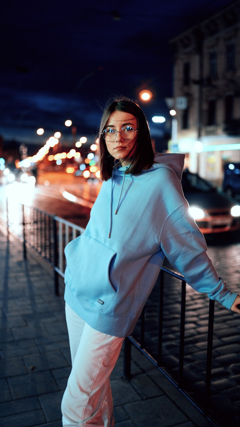 Young woman with glasses standing outside during Neptune retrograde 2021.