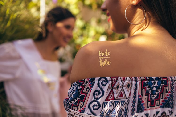 Woman with "bride tribe" temporary tattoo to pair with bachelorette party captions on Instagram