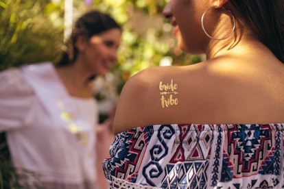 Woman with "bride tribe" temporary tattoo to pair with bachelorette party captions on Instagram