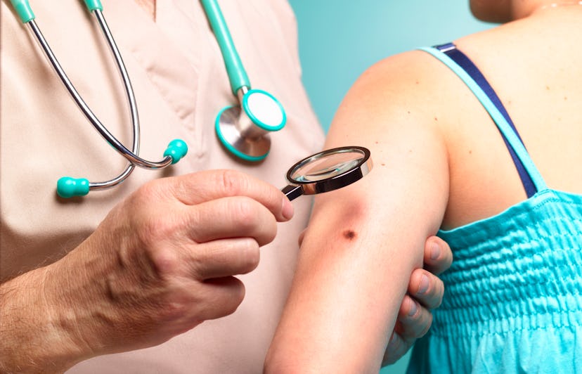 Dermatologist looking at woman's arm 