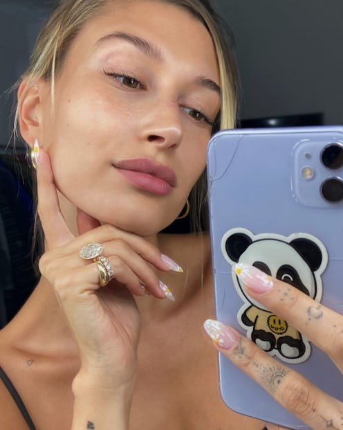 Daisy nails, summer's cutest design for your digits, as seen on Hailey Bieber. The model's manicuris...