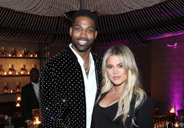 Khloé Kardashian in a black dress and Tristan Thompson in a white shirt and black rhinestone jacket