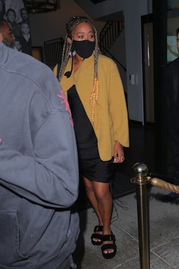 Naomi Osaka wearing a yellow blazer, black dress, and black sandals while on a date night in 2021. 
