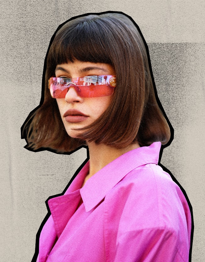 A woman wearing pink shirt and glasses with bangs haircut