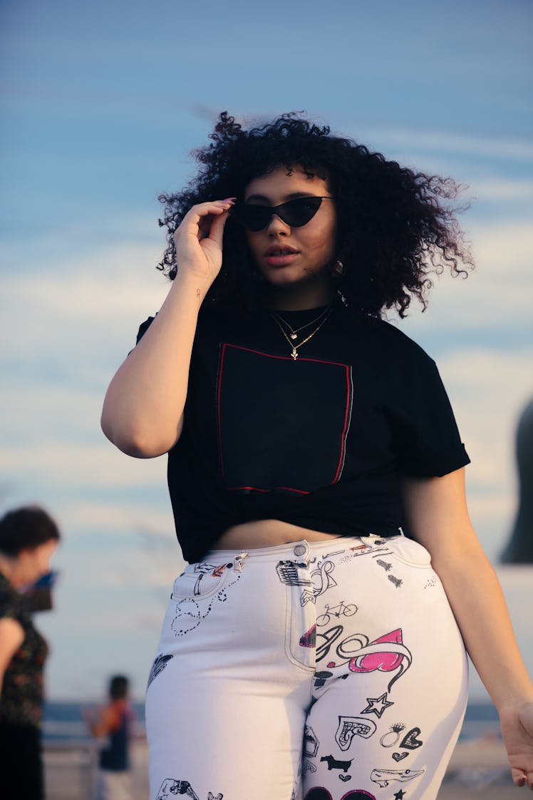 Young woman with sunglasses, ready to post a pic with a sarcastic Instagram caption.