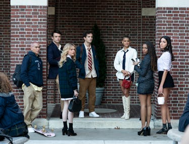 The cast of Gossip Girl in front of a brick wall in their private school uniforms paired with Prada ...