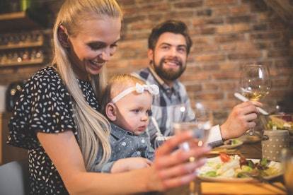 family having meal at a restaurant with baby sitting in mom's lap