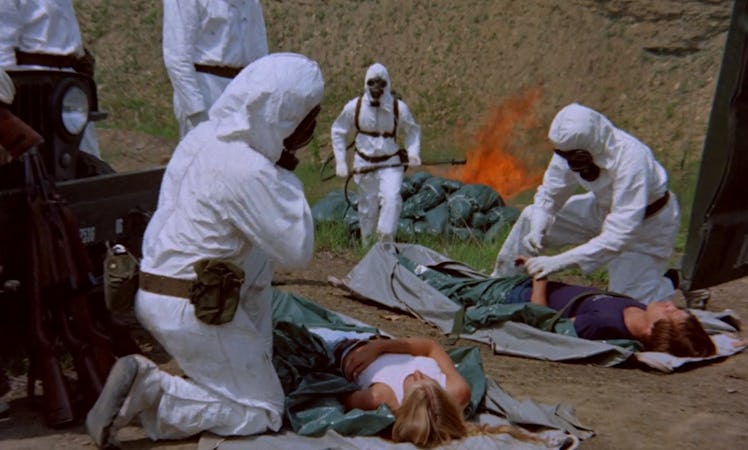 A group of people in hazmat suits are checking on the bodies of people in the movie The Crazies