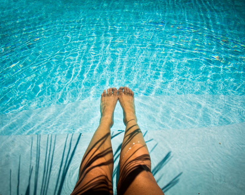 legs floating in pool