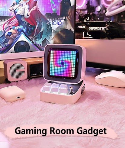 Divoom's pink Pixel Art speaker which looks like a mini computer sits on a pink plush mat next to a ...