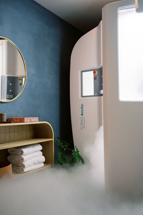 The opened door to a cryotherapy chamber, with cold steam coming out