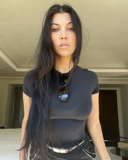 Kourtney Kardashian posing for a photo wearing all black and her hair down