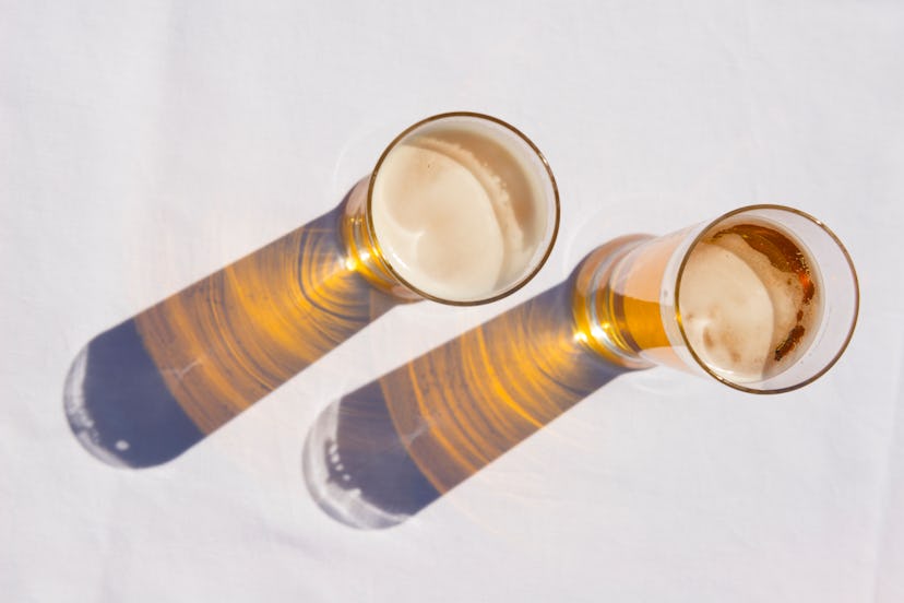 overhead shot of beer glasses on a white table 