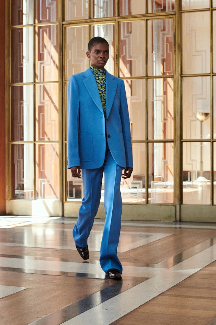 Model walking while wearing a blue suit
