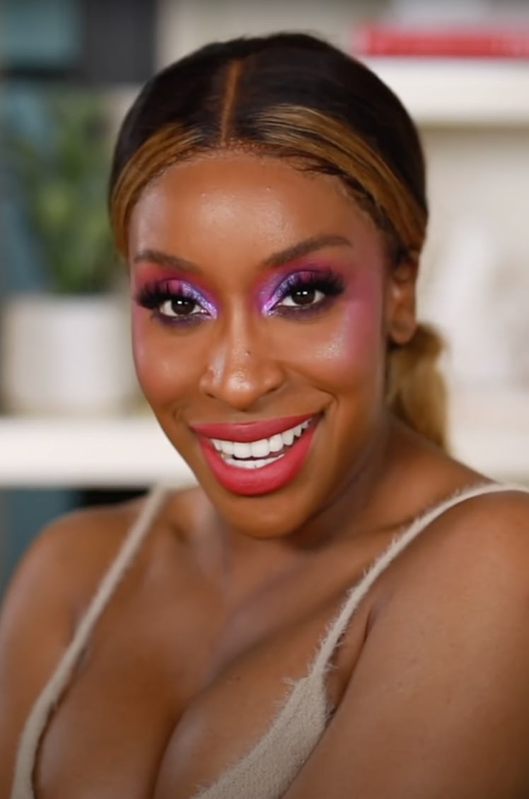 Jackie Aina rocking holographic purple eyeshadow and a rosy blush.