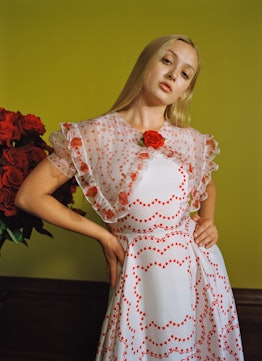 Grace Piehl posing in white dress with huge white collar decorated with red roses