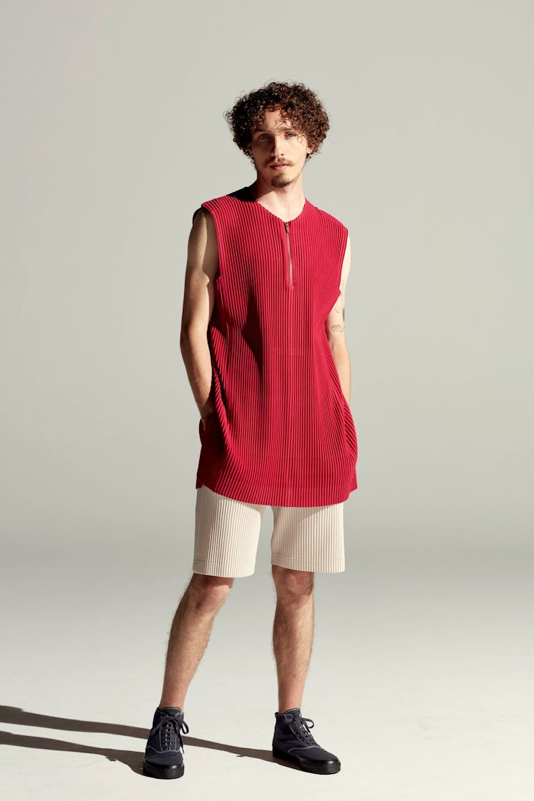 A model in a red tank top and white shorts by Issey Miyake at Men’s Fashion Week Spring 2022