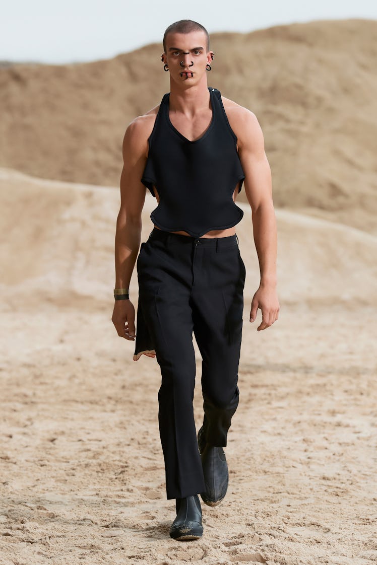 A model in a black corset top and black trousers at Men’s Fashion Week Spring 2022