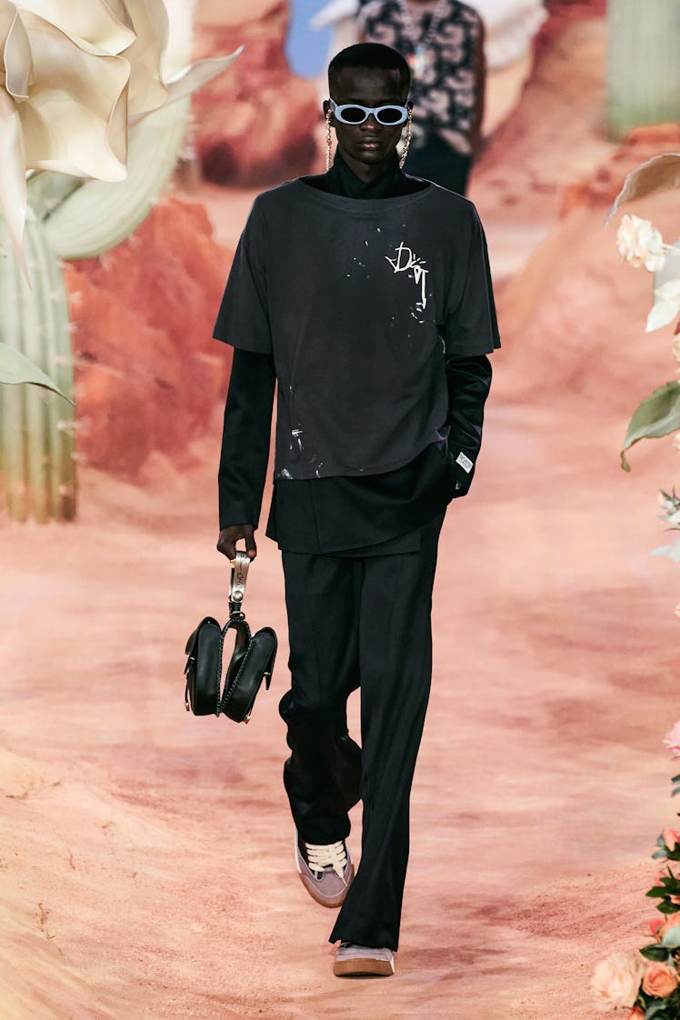 A model in a black shirt, turtleneck and pants at Men’s Fashion Week Spring 2022