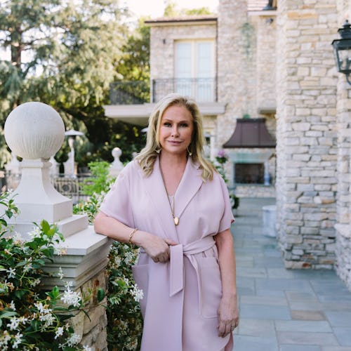 Kathy Hilton stands near a garden as she poses for Bustle.
