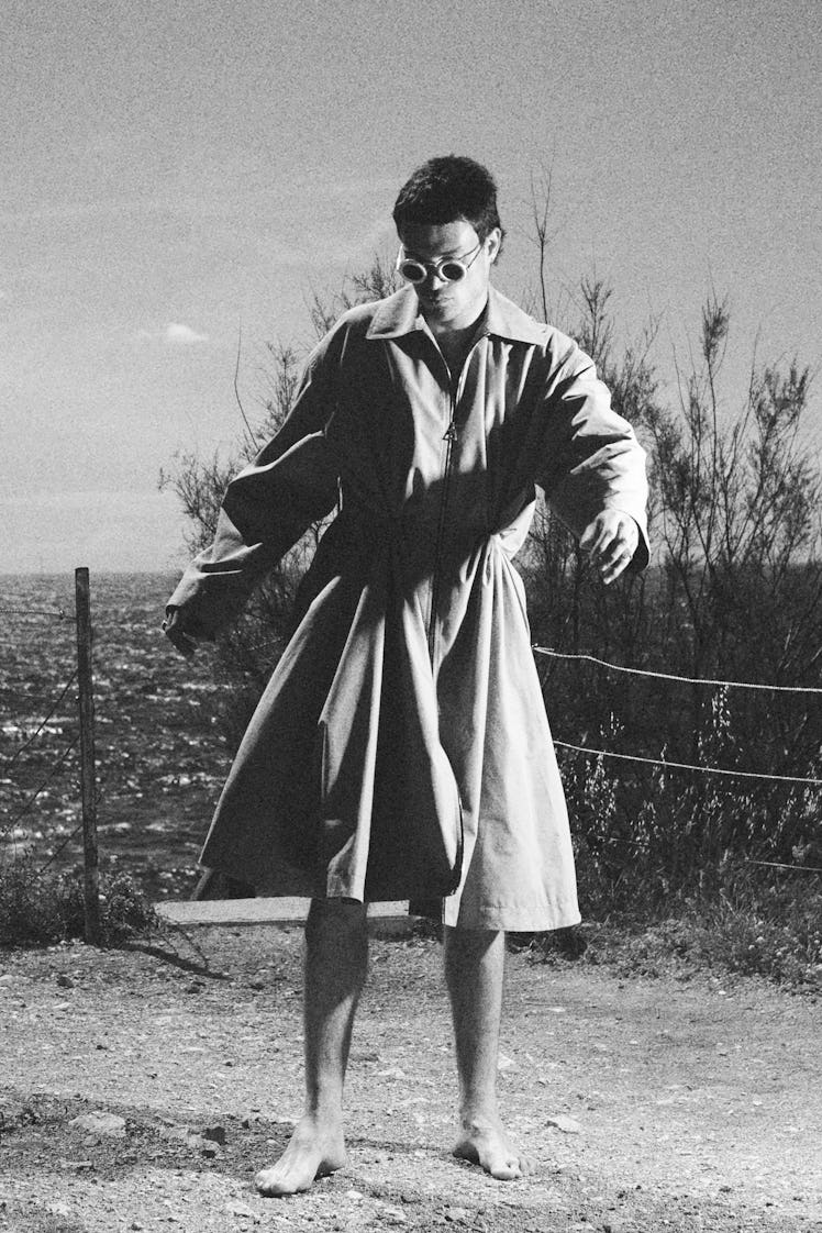 A model in a Loewe coat in a black-and-white photograph at Men’s Fashion Week Spring 2022