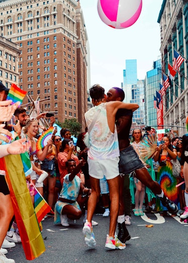 A couple kissing while surrounded by a cheering crowd at the Pride Celebration in New York