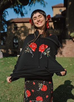 Zoe Bleu smiling, while posing outside on the sunlight wearing Rodarte’s fit